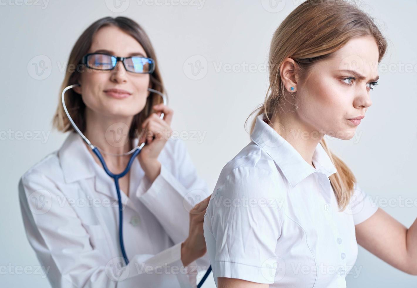 de patient vände sig henne tillbaka till de läkare i en medicinsk klänning med en stetoskop foto