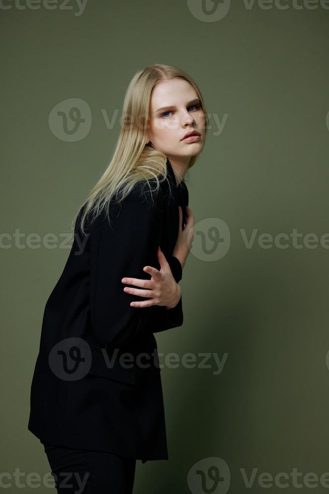 konst mode Foto skjuta. professionell blond modell innehar själv kramar med både händer halvvänt utseende på de kamera Framställ på en grön bakgrund i de studio