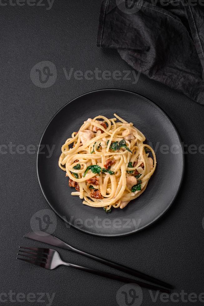 utsökt pasta med spenat, Sol torkades tomater, ost, lök foto