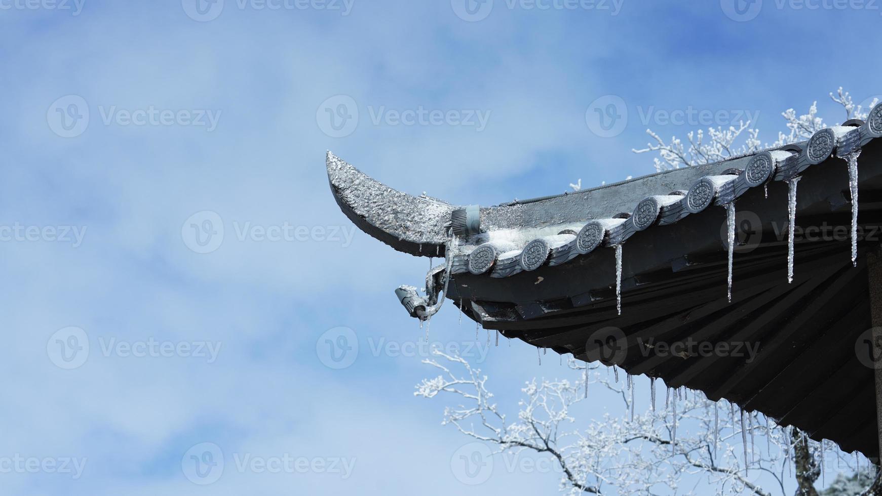 de frysta tappade is kolonner hängande från de takfot i vinter- foto