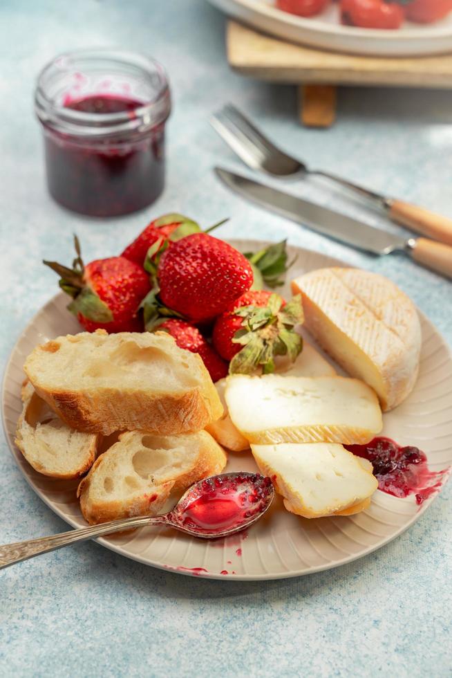 frukostplatta med ost, bröd, jordgubbar och sylt, närbildsvy foto