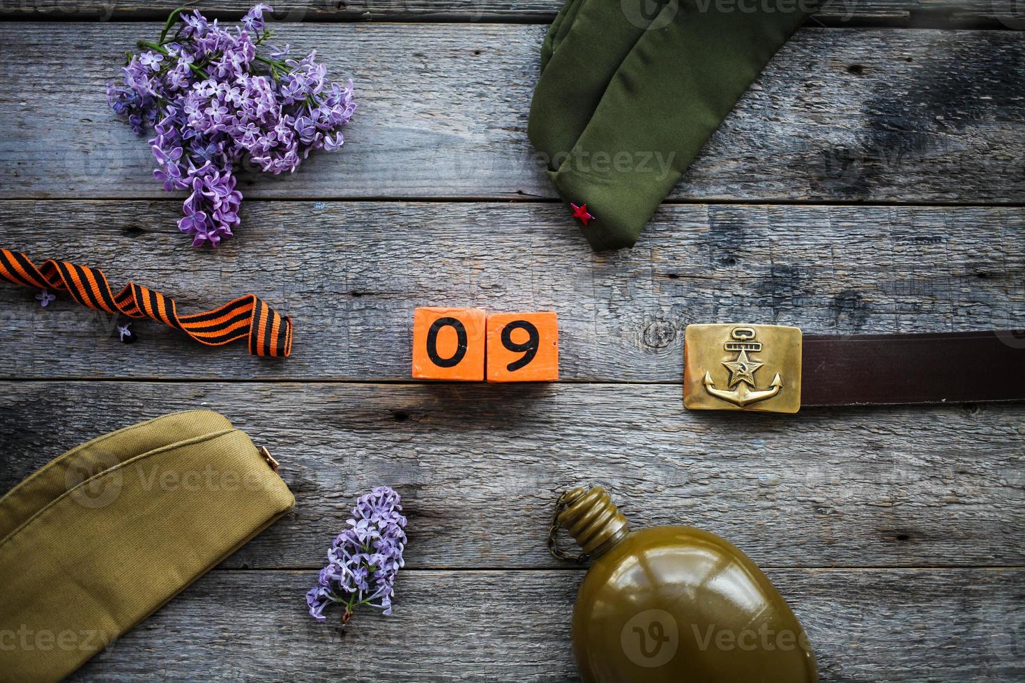 flaska, keps , george band, soldat bälte med en femspetsig stjärna med en hammare och skära och en trä- kalender med de datum text i ryska Maj 9. seger dag. foto