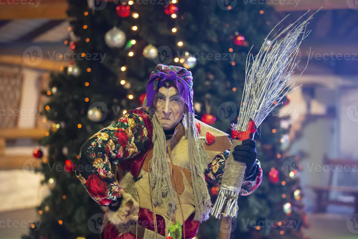 baba yaga med en kvast på de bakgrund av de jul träd. foto