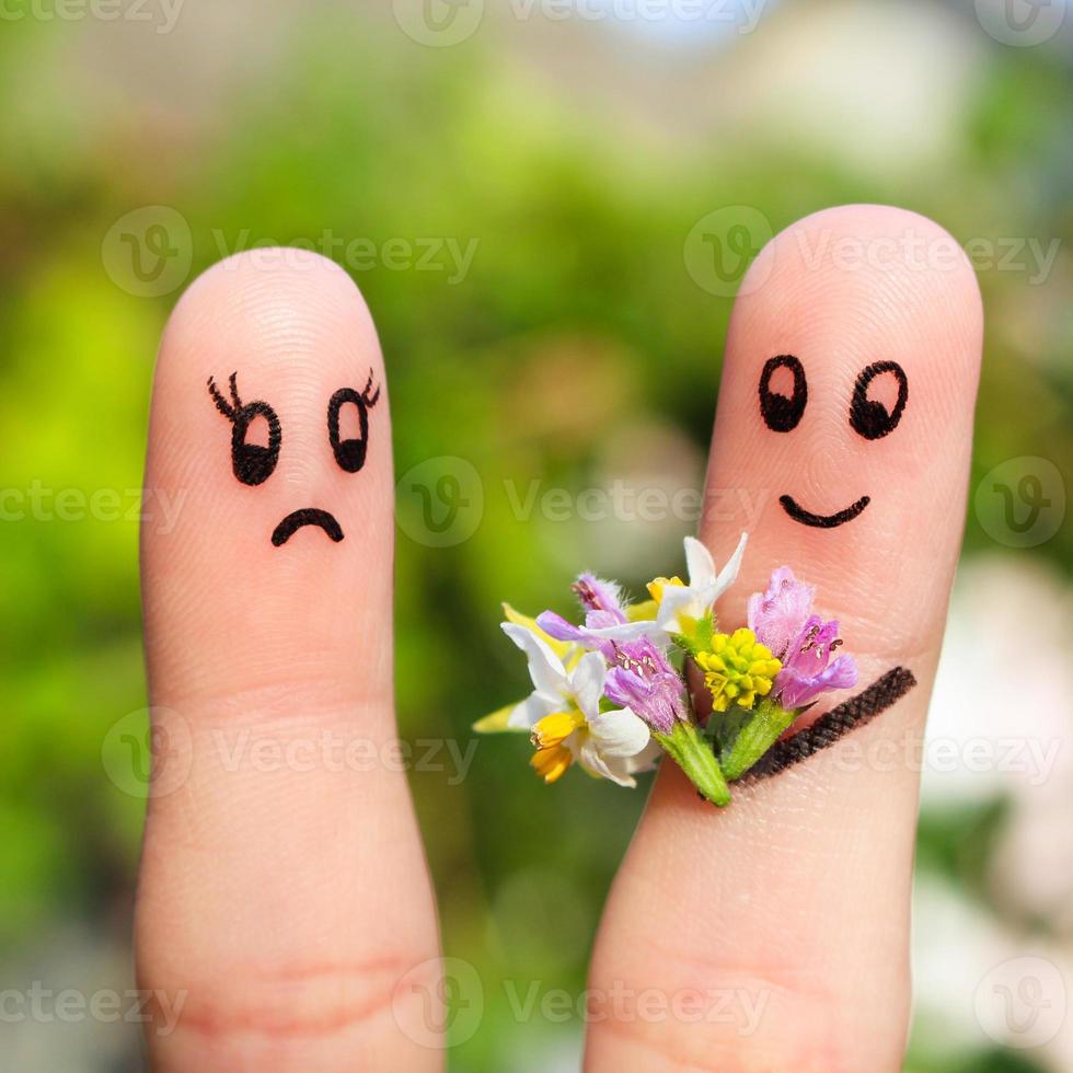 finger konst av par. man ger en kvinna en bukett av blommor, hon är inte nöjd. foto