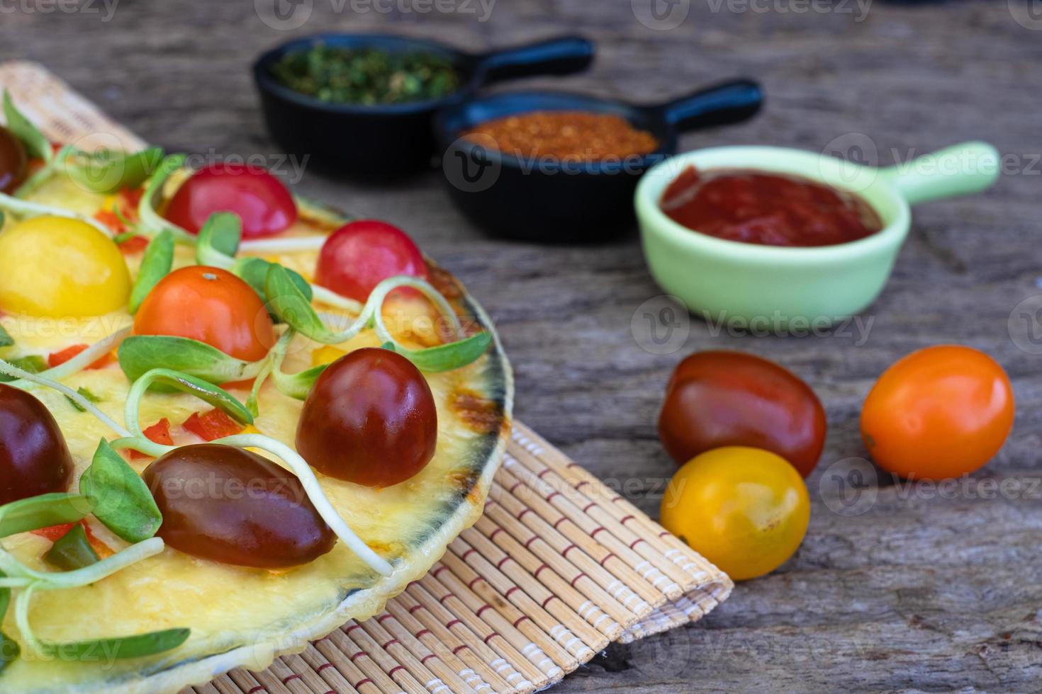 närbild hemlagad vegetarisk pizza med körsbärstomater foto