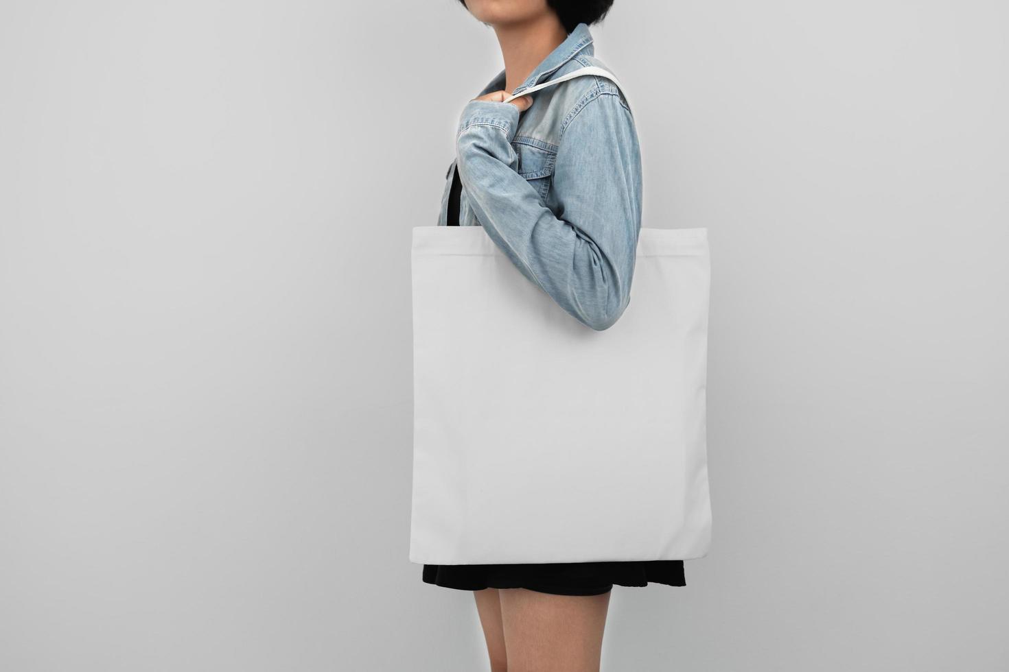 ung kvinna innehav eco bomull väska isolera på vit bakgrund foto