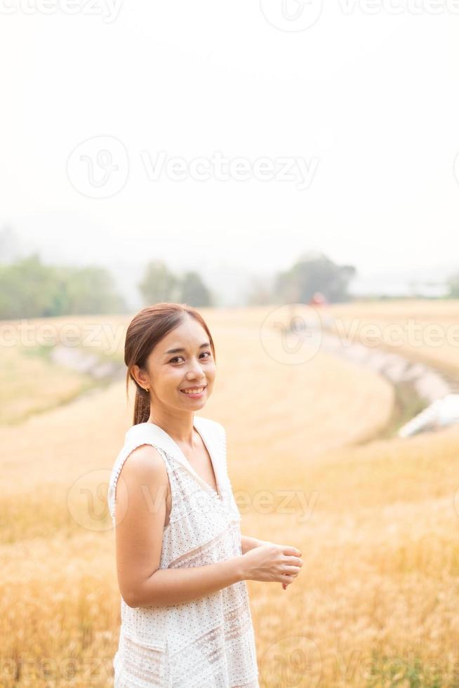 ung asiatisk kvinnor i vit klänningar i de korn ris fält foto