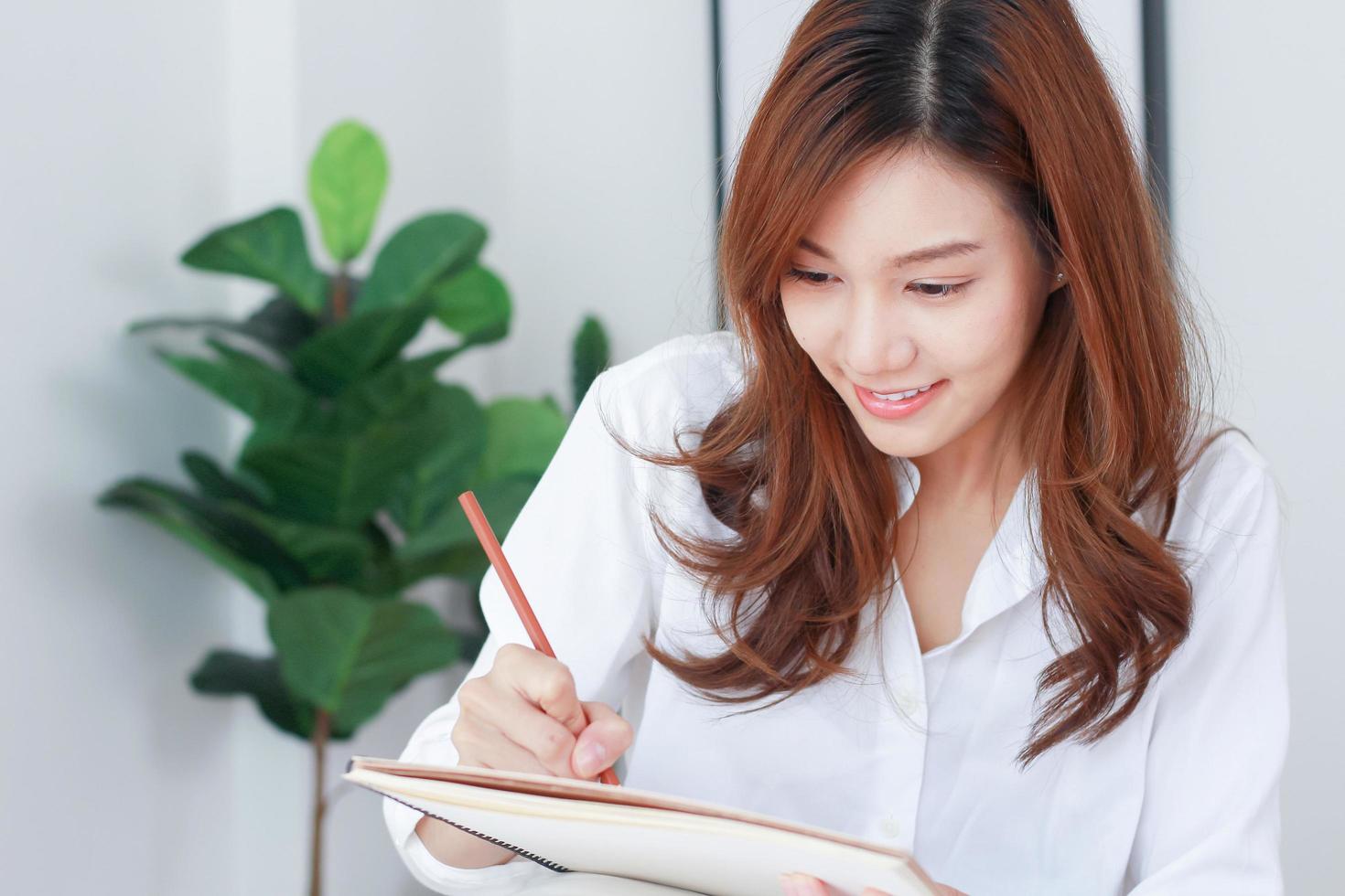 asiatisk affärskvinna skriver ner marknadsföringsinformation foto