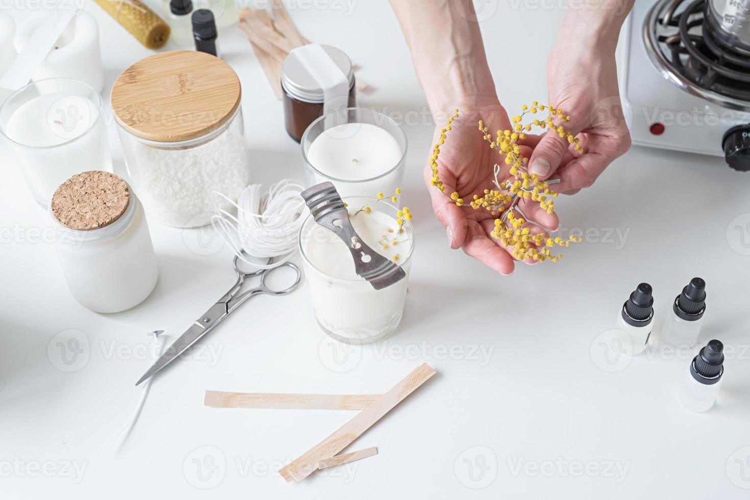 närbild av kvinna händer dekorera handgjort ljus foto