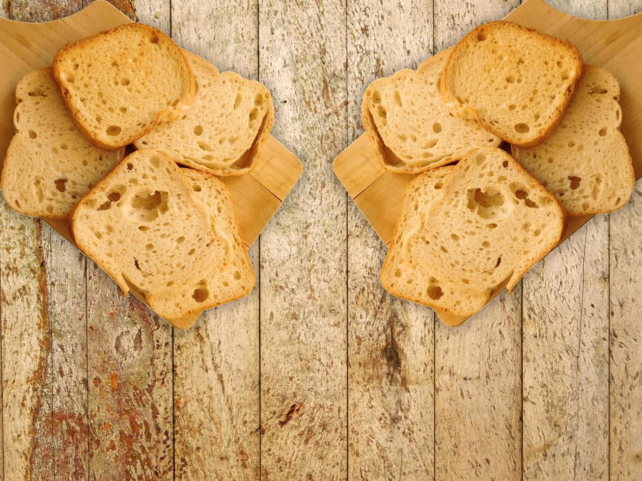 skivad rostat bröd på en träskärbräda på en träbordbakgrund foto