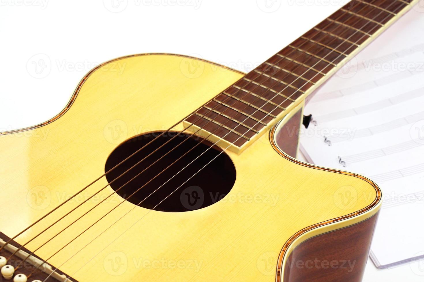 akustisk gitarr med musik anteckningar mot vit bakgrund. underhållning, kärlek och musik begrepp. foto