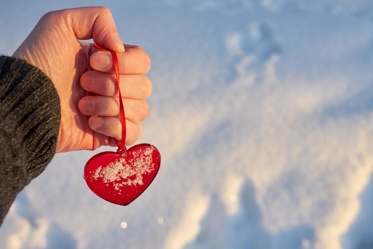 rött hjärta i hand med snö foto