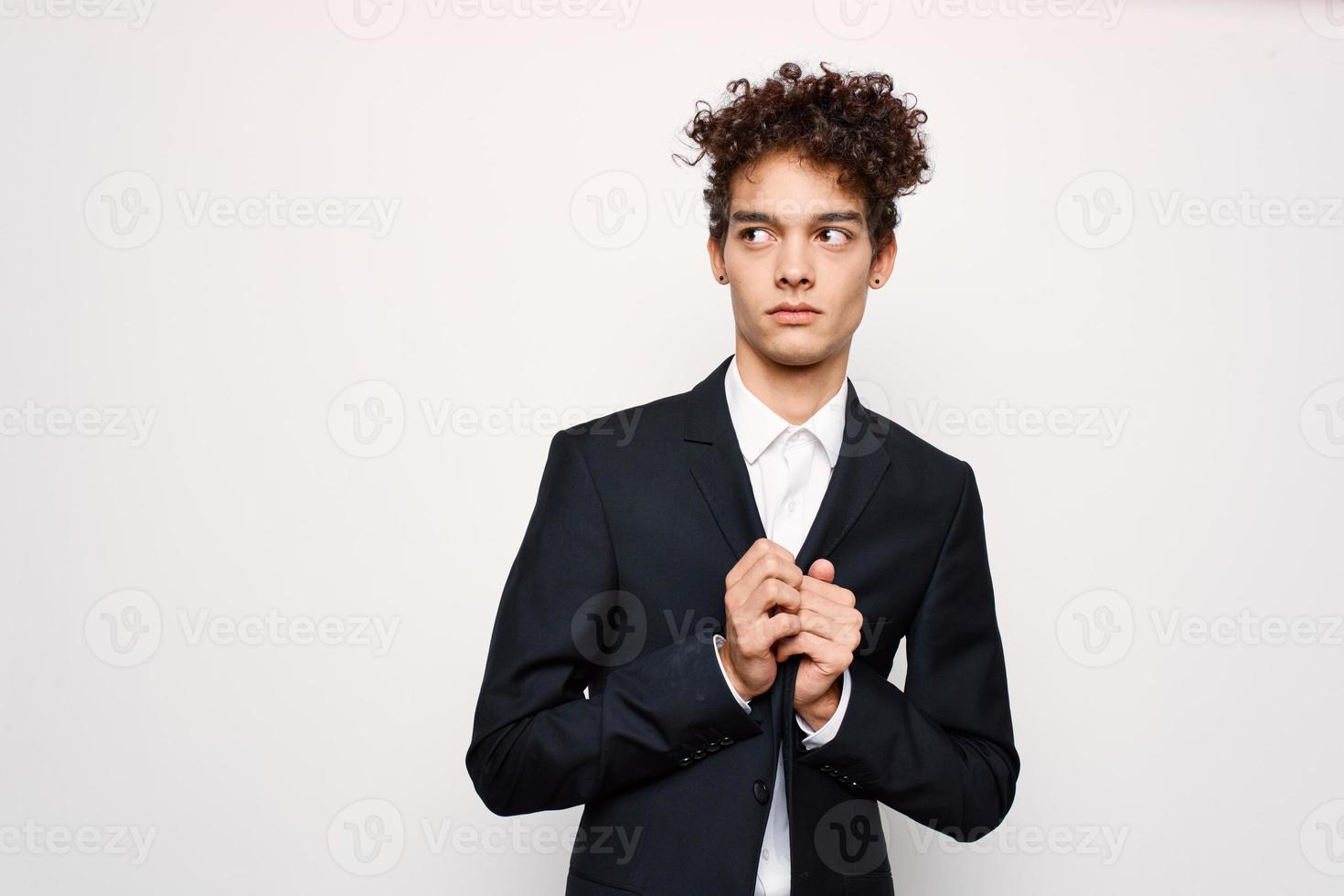 kille med lockigt hår i en kostym mode svart blazer modern stil foto