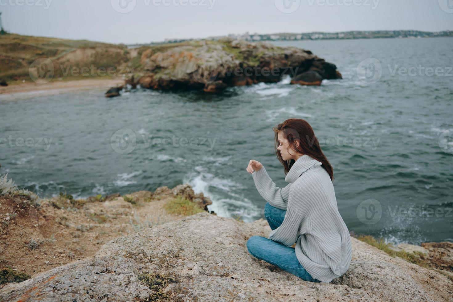 skön kvinna strand turism molnig väder sten kust avslappning begrepp foto