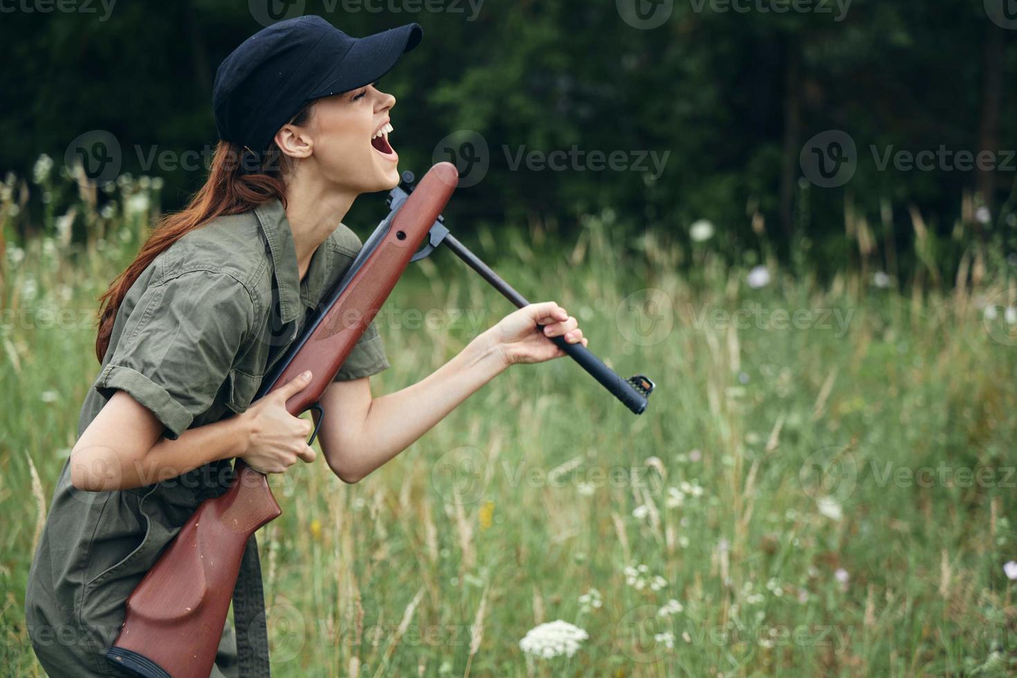 militär kvinna roligt vapen i hand ladda om färsk luft grön löv foto