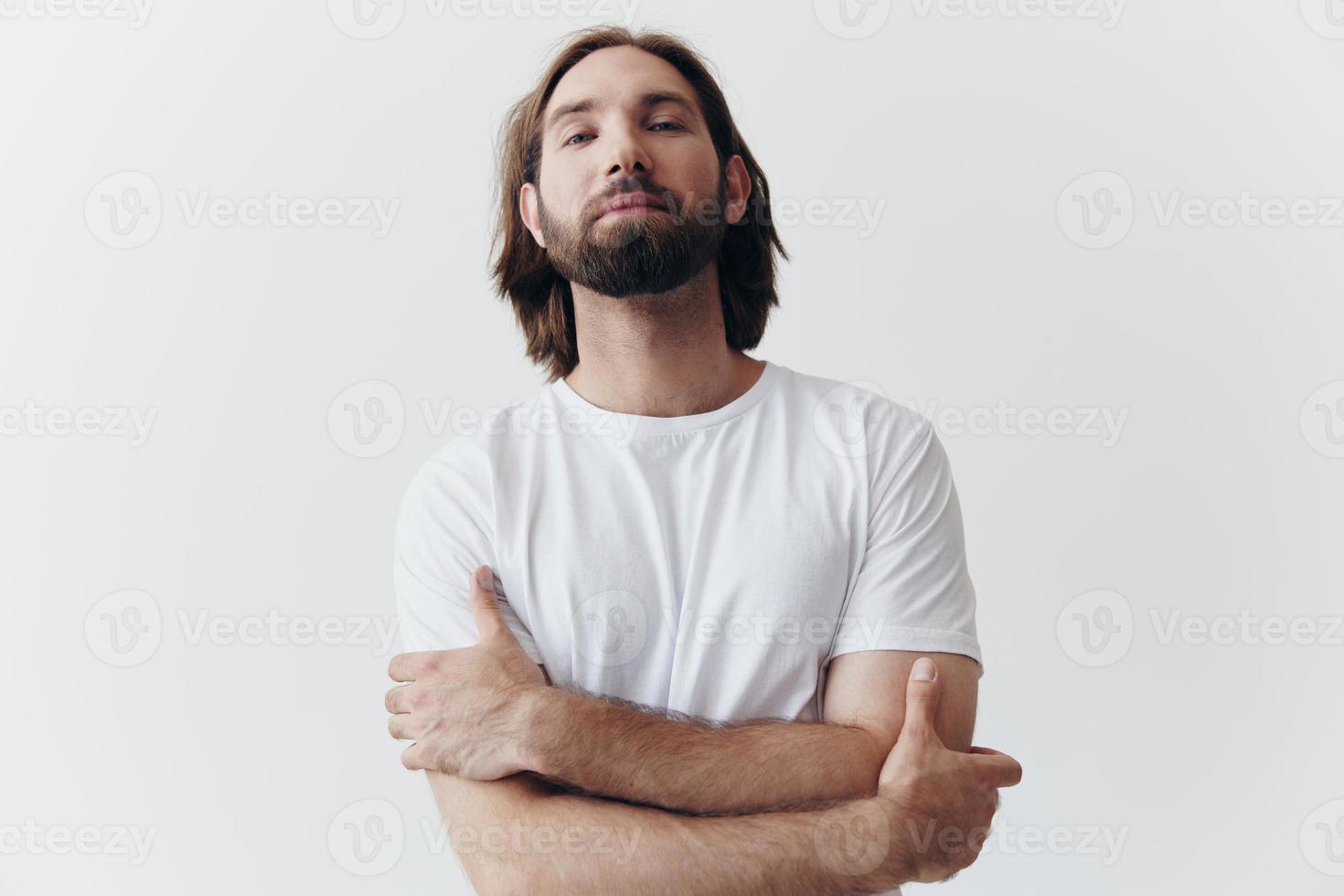 porträtt av en man med en svart tjock skägg och lång hår i en vit t-shirt på en vit isolerat bakgrund foto