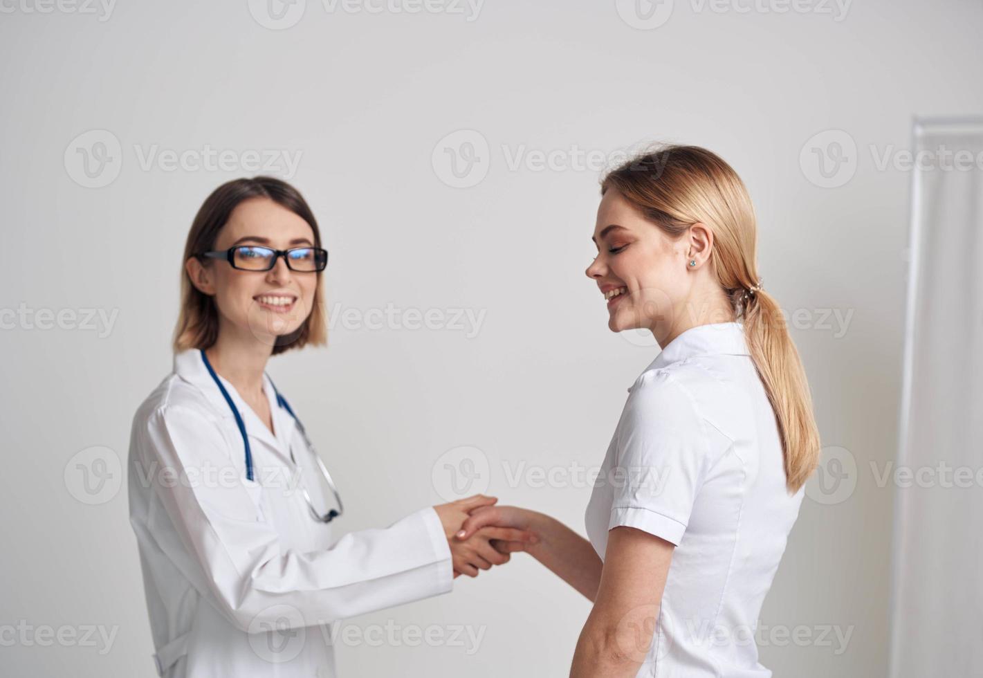 en kvinna i en t-shirt kom till ser en läkare i en medicinsk klänning foto