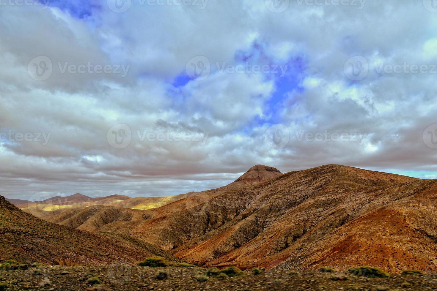 tömma mystisk bergig landskap från de Centrum av de kanariefågel ö spanska fuerteventura med en molnig himmel foto