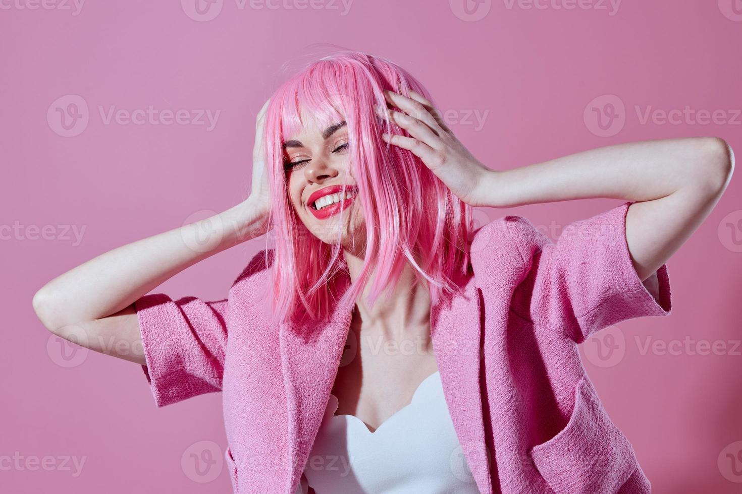 Söt ung kvinna rosa jacka innehav hår kosmetika rosa bakgrund oförändrad foto