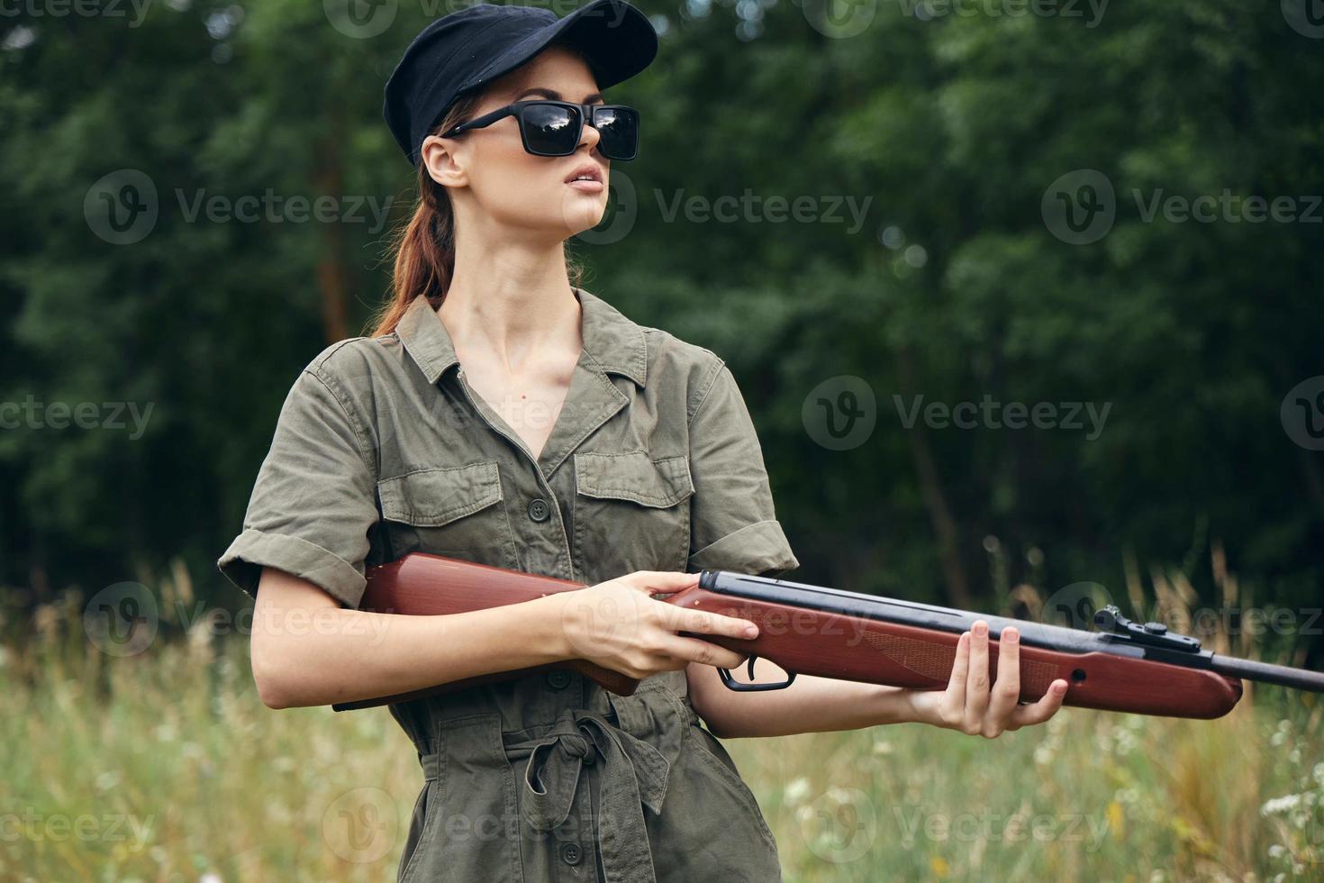 kvinna på utomhus- solglasögon vapen i hand jakt färsk luft foto