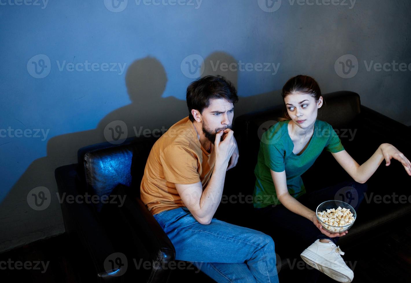 en man och en kvinna är tittar på en film i de bio på de soffa inomhus foto