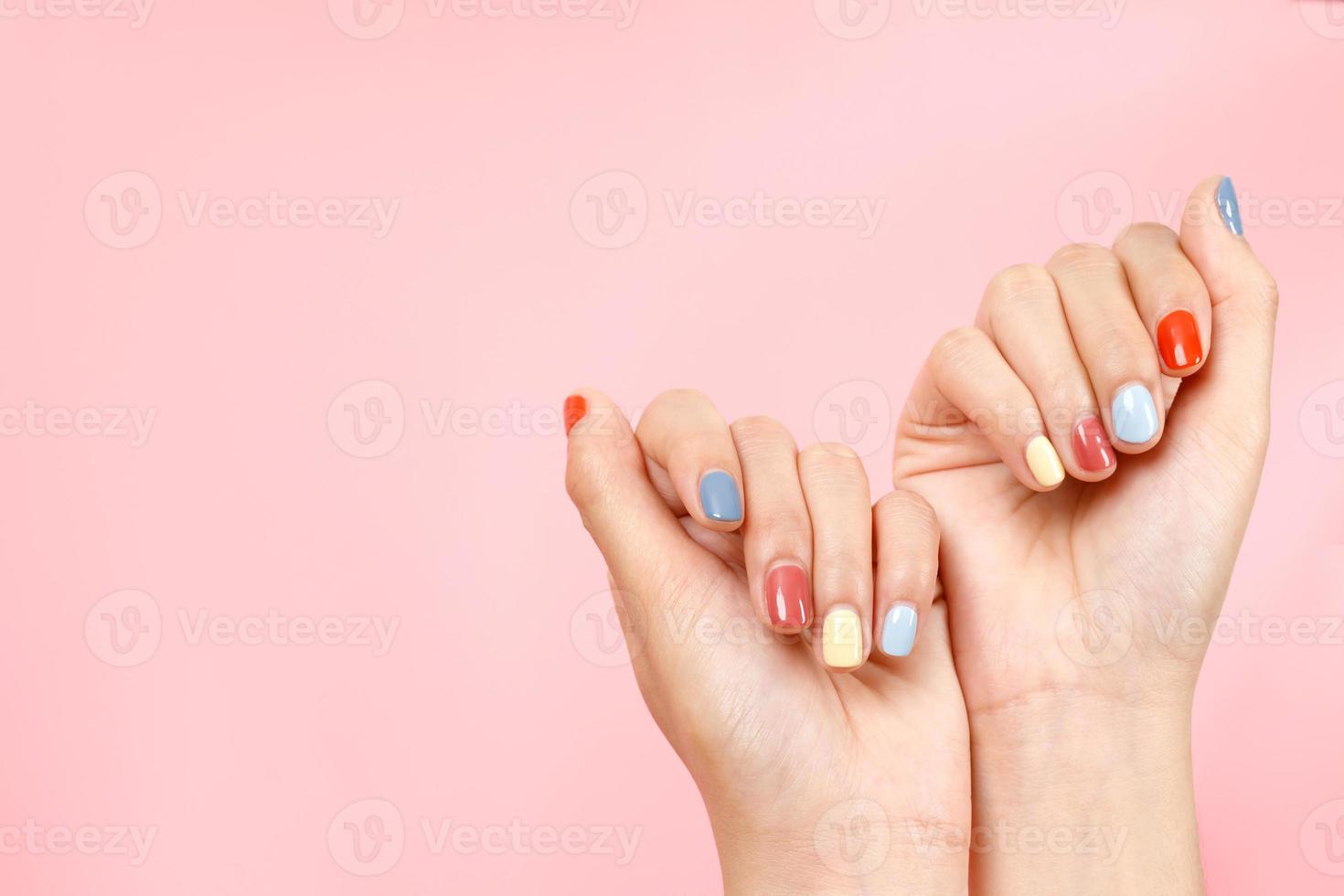 skön kvinna hand målning akryl gel spikar. mode stil. rosa bakgrund. foto