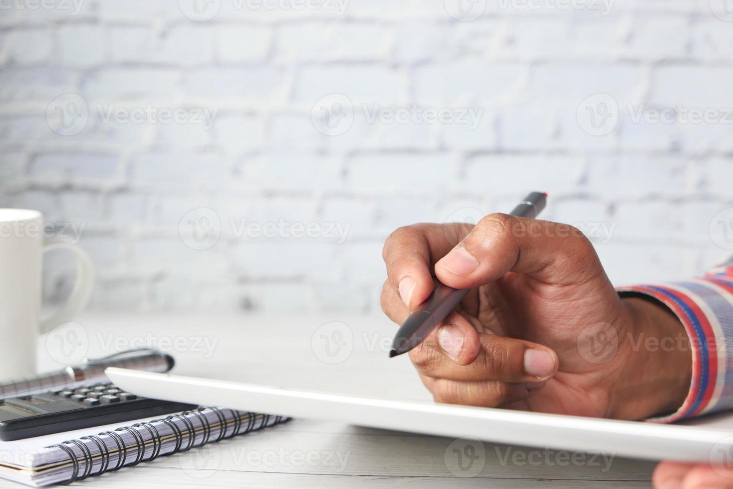 mans hand som arbetar på digital tablet med pennan foto