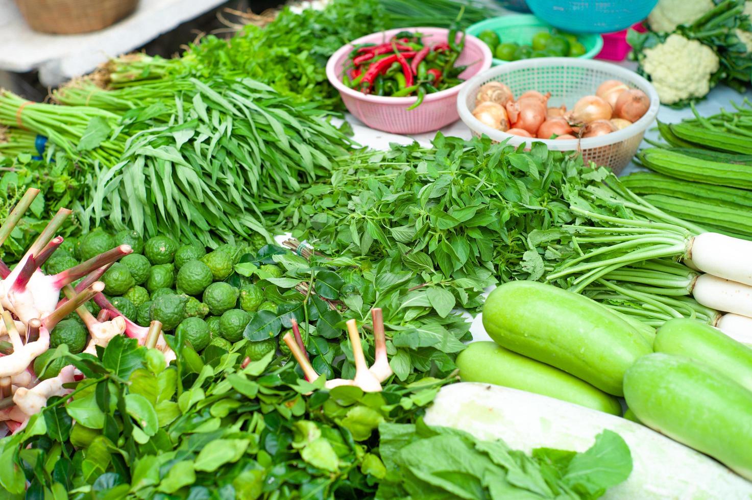 närbild av olika typer av färska grönsaker som visas i utomhusbutik foto