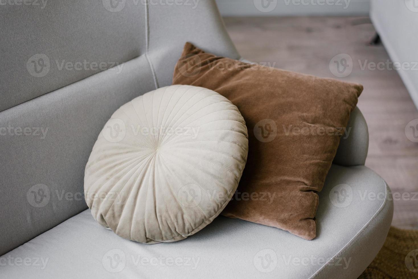 runda och fyrkant mysigt kuddar på en grå soffa i de levande rum närbild foto