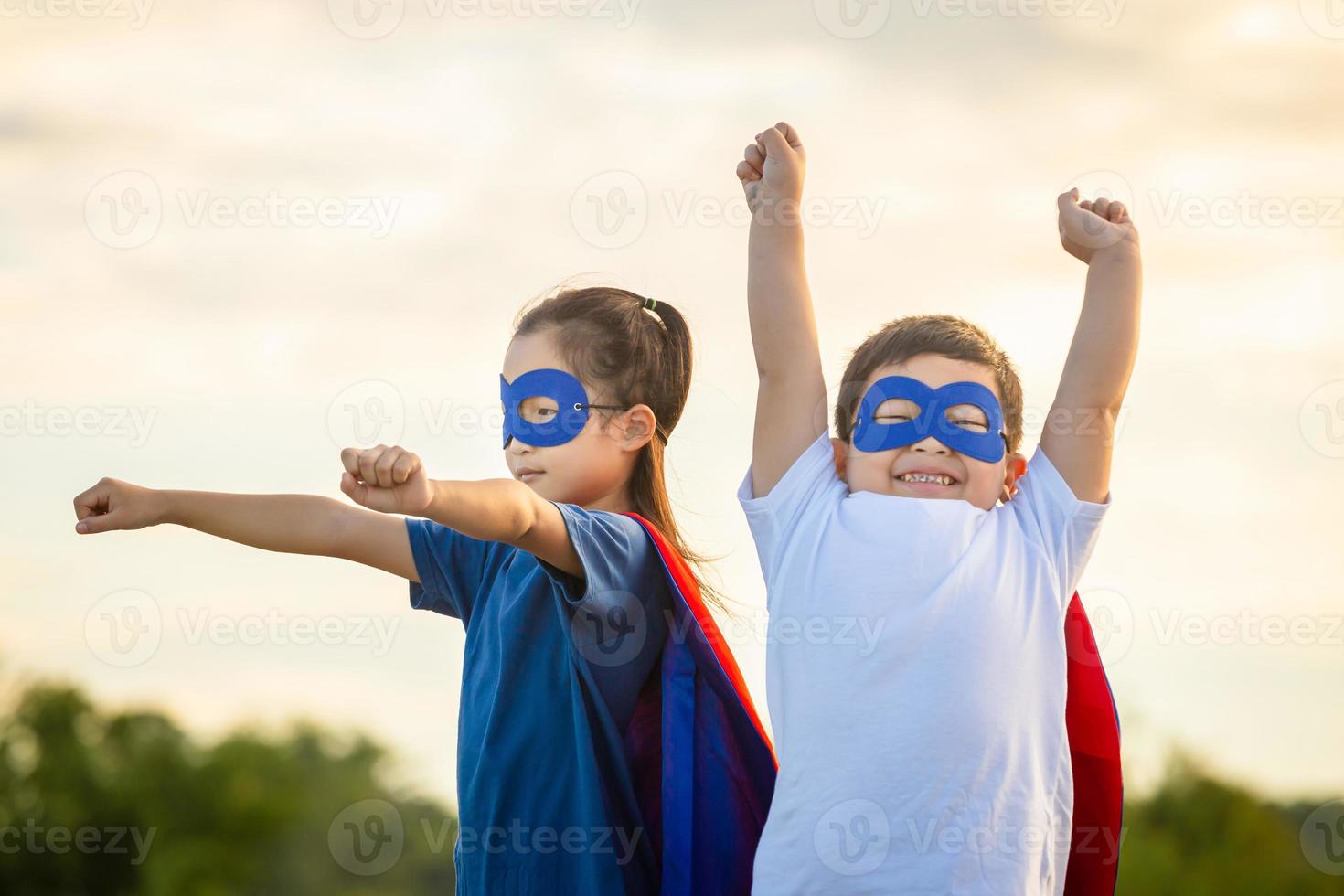 superhjältar barn vänner har roligt utomhus, bror och syster spelar utomhus, pojke och flicka spelar utomhus- foto