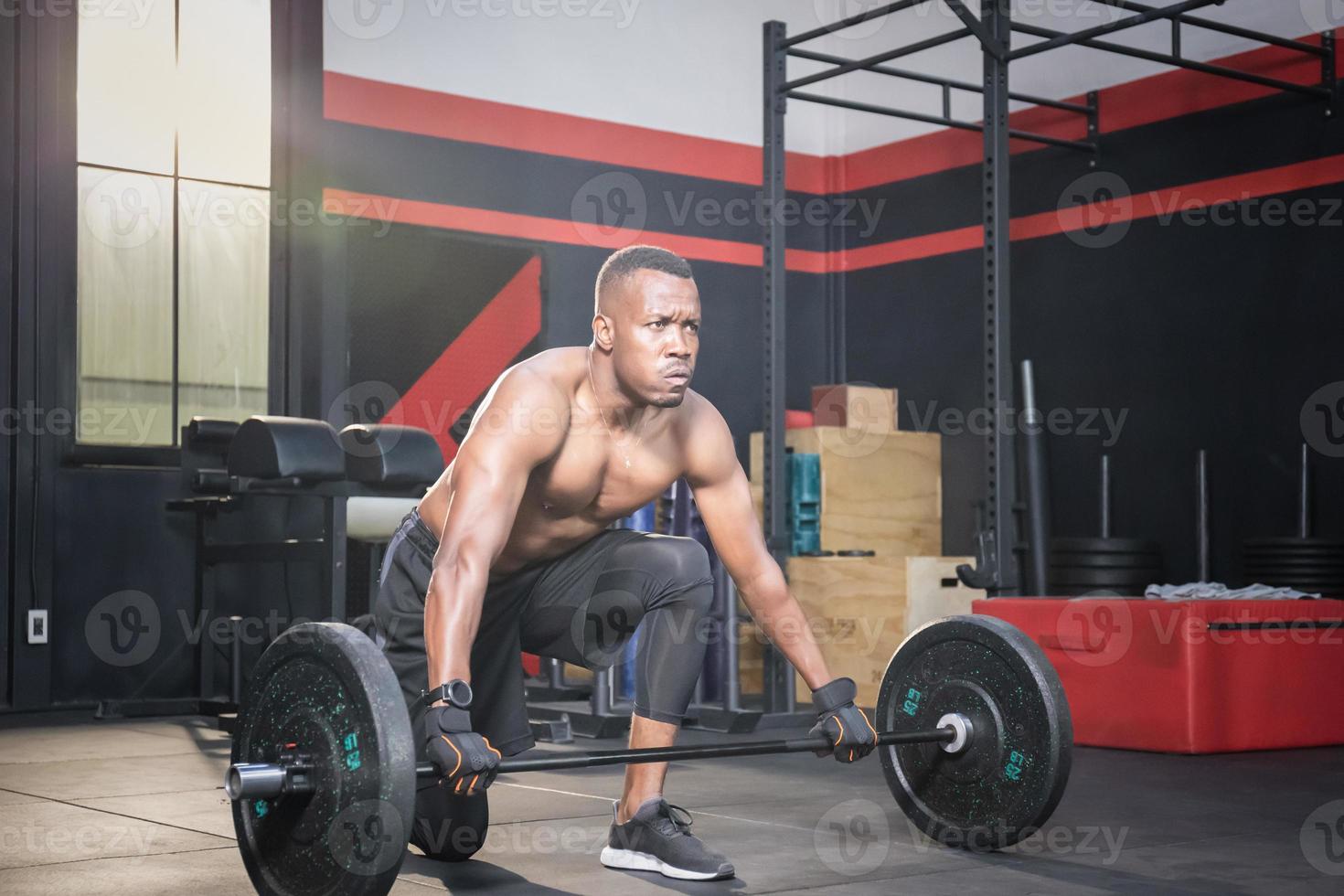 fitness man lyfter vikter i gym fitness, muskulös man tränar i gym gör övningar med skivstång vikt foto