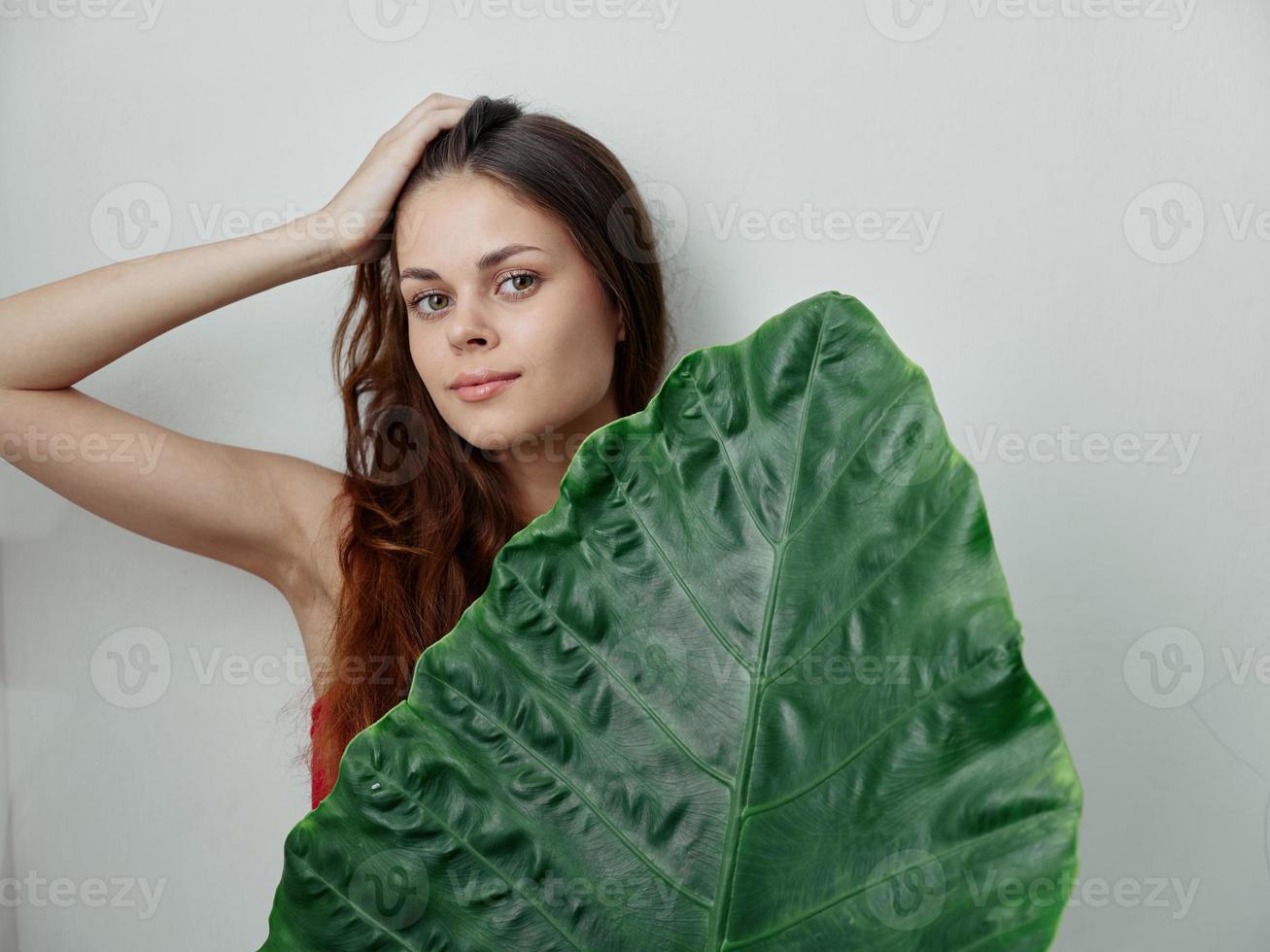 Söt kvinna innehar henne hand på henne huvud grön äta exotisk ljus bakgrund foto