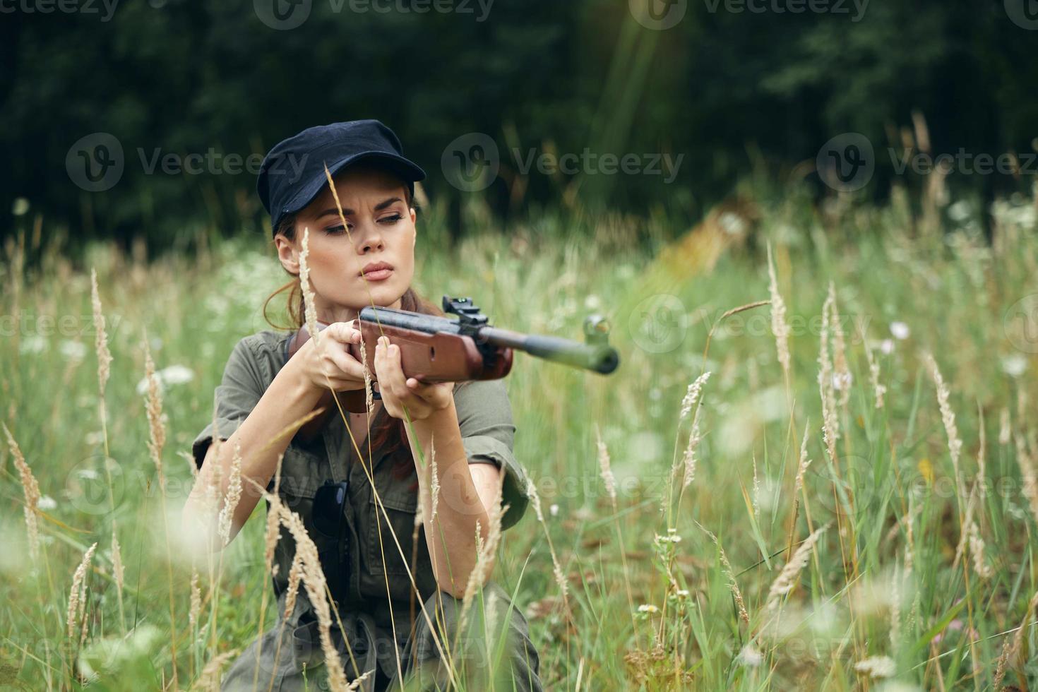 kvinna på utomhus- vapen i de händer av de grön overall av de skydd foto