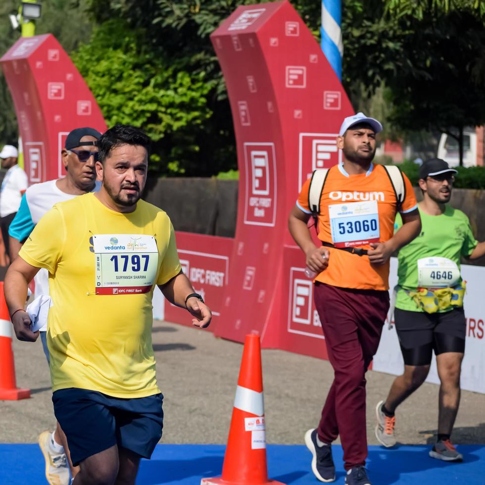 ny delhi, Indien - Mars 16 2023 - vedanta delhi halv maraton lopp efter covid i som maraton deltagarna handla om till korsa de Avsluta linje, delhi halv maraton 2022 foto