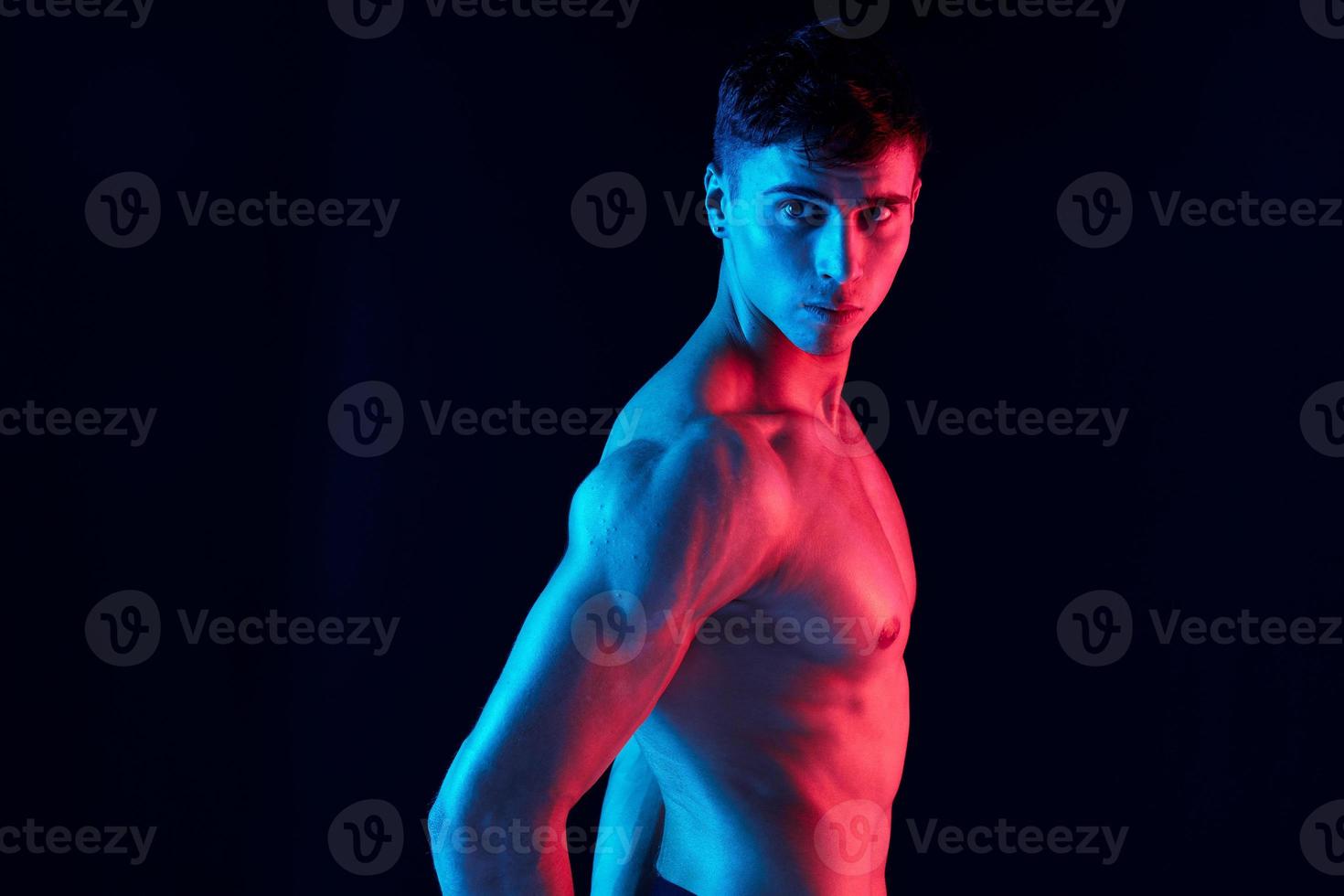manlig idrottare på en neon bakgrund modell uppblåst torso foto