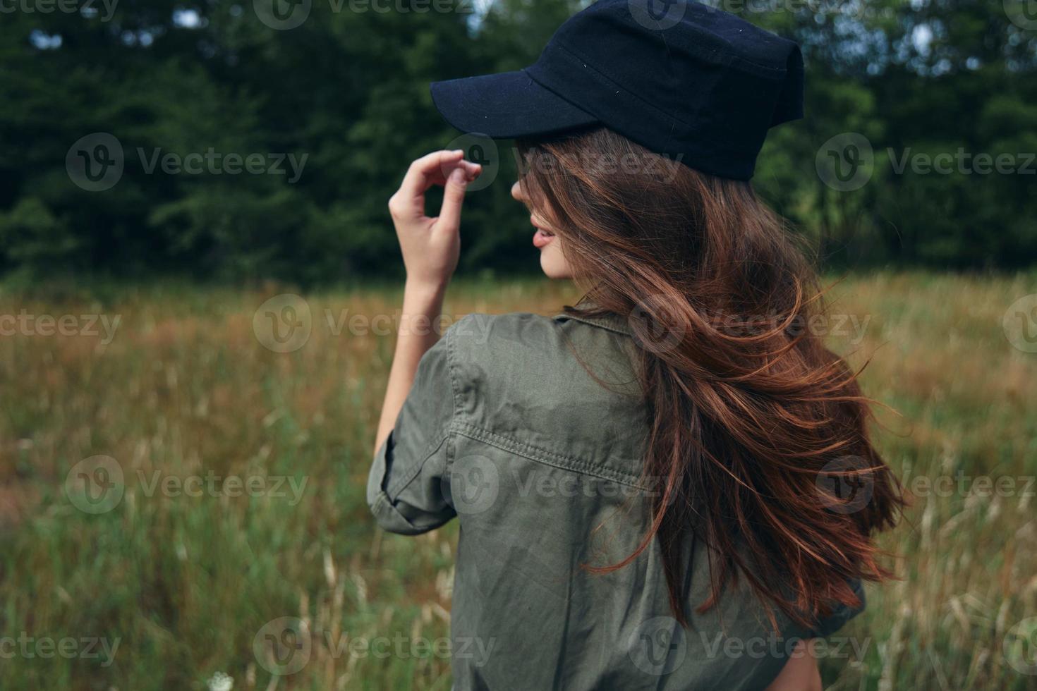kvinna i en keps med lång hår grön skjorta natur foto