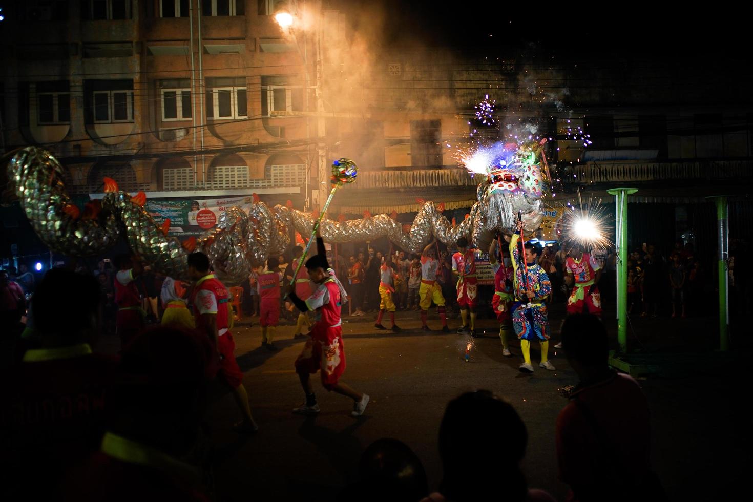 ratchaburi, Thailand 2018 - kinesiskt nyårsfirande av paraden att manipulera en flygande drake med fyrverkeri på den offentliga gatan i centrum foto