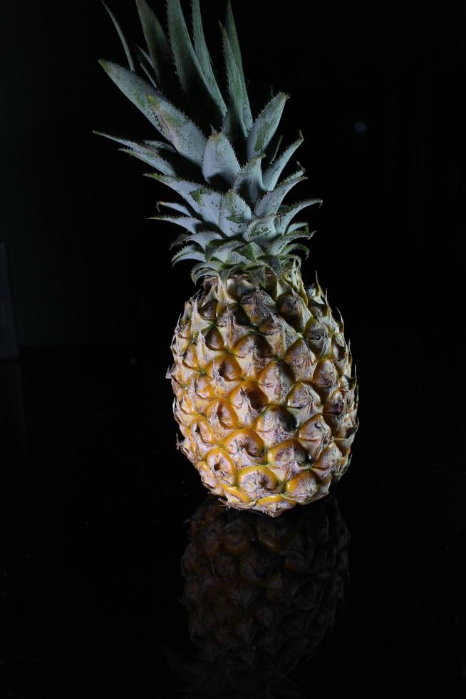 ananas frukt isolerat på svart bakgrund med reflexion i dess skugga. foto