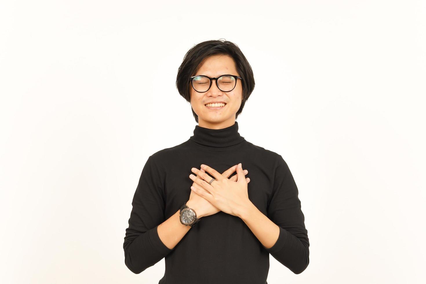 händer på bröst tacksam gest av skön asiatisk man isolerat på vit bakgrund foto