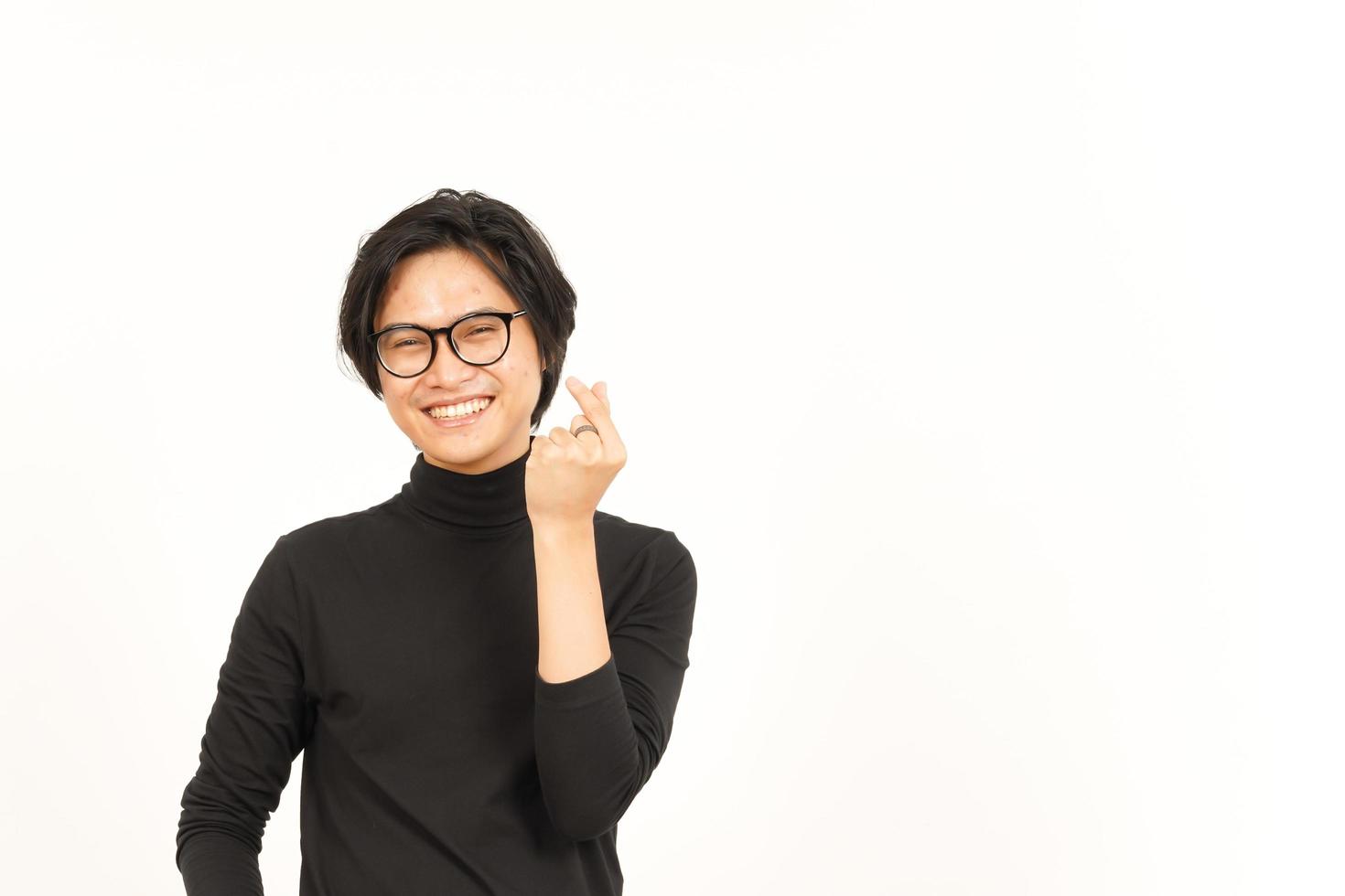 leende och som visar koreanska kärlek finger av stilig asiatisk man isolerat på vit bakgrund foto