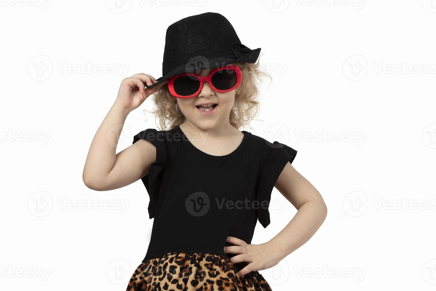 rolig barn. liten flicka i en svart hatt och solglasögon på en vit bakgrund. porträtt av en skön modern bebis flicka. fyra år gammal bebis blond. foto
