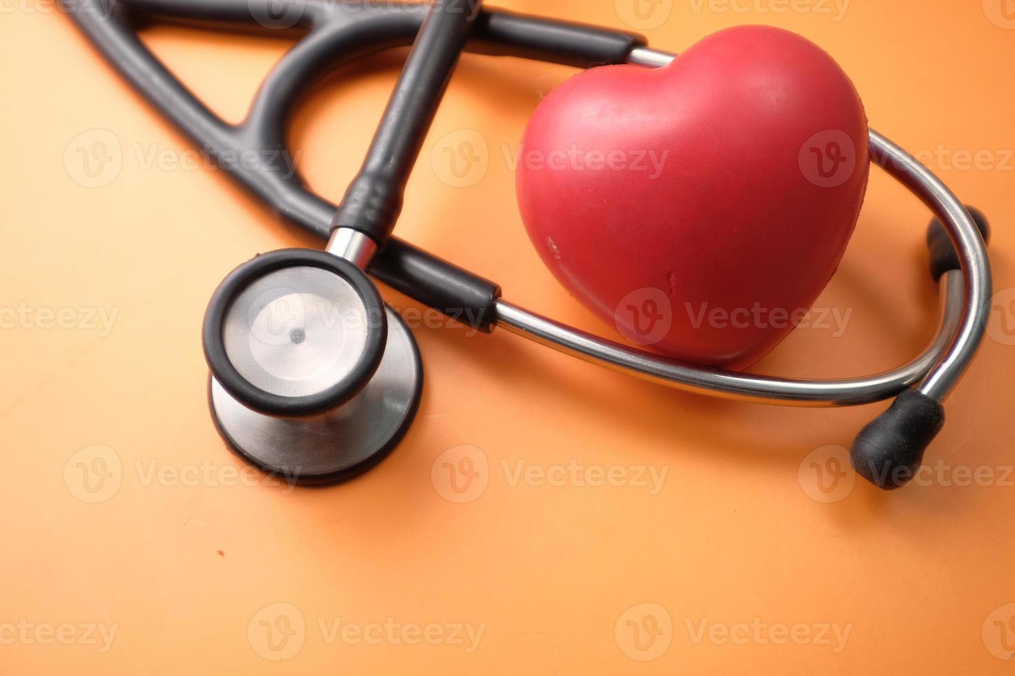 hjärta form symbol och stetoskop på orange bakgrund foto