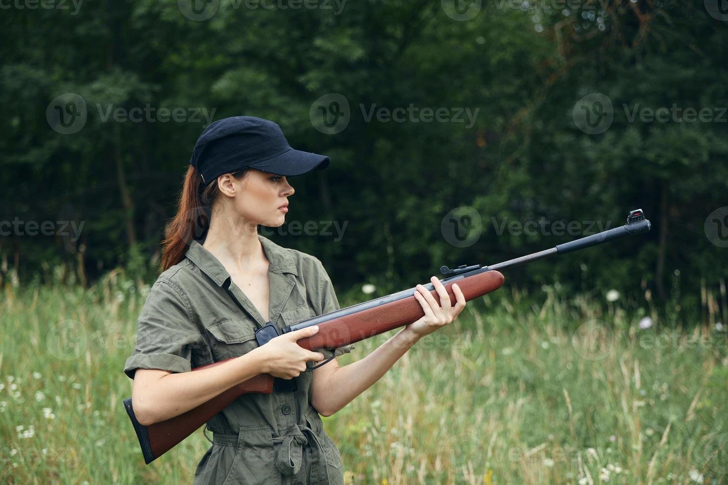 kvinna soldat innehar vapen i sida se grön löv foto