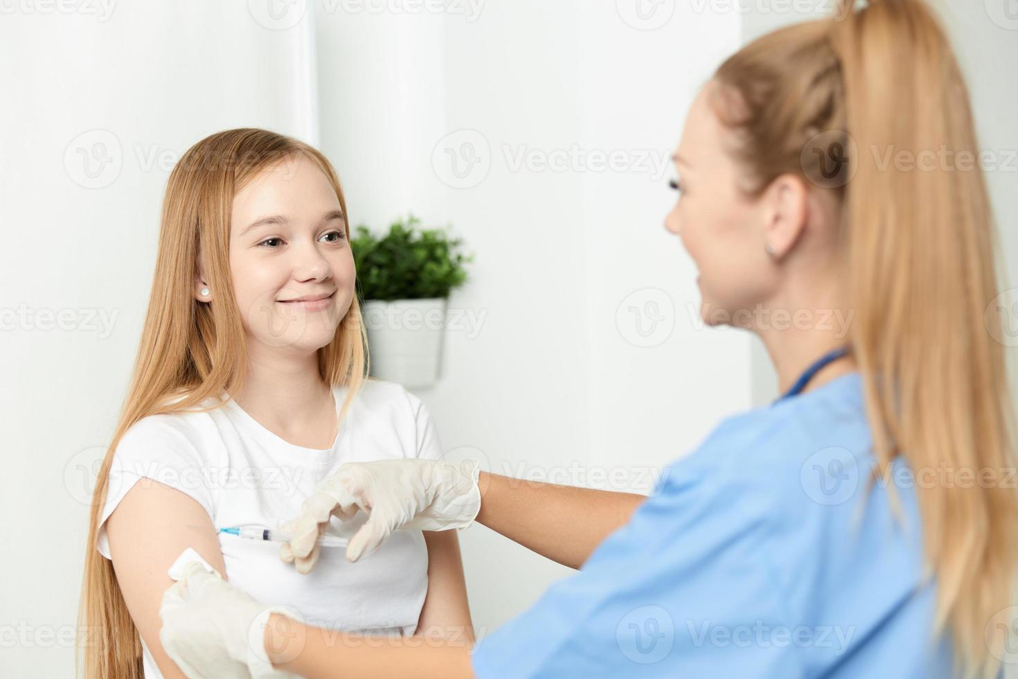 kvinna läkare ger en flicka ett injektion i de ärm vaccination foto