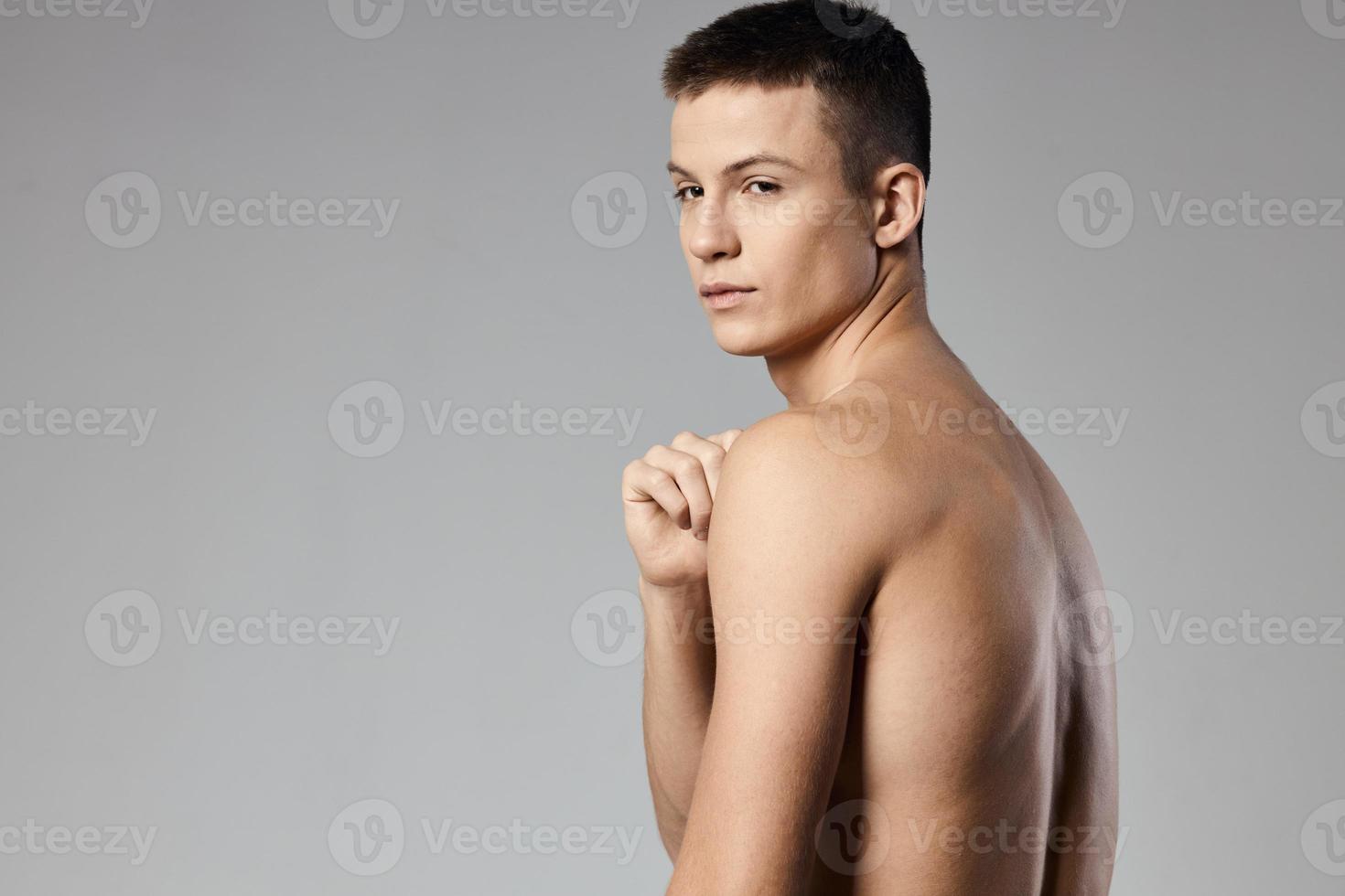 stark idrottare med utbuktande ärm muskler naken tillbaka grå bakgrund foto