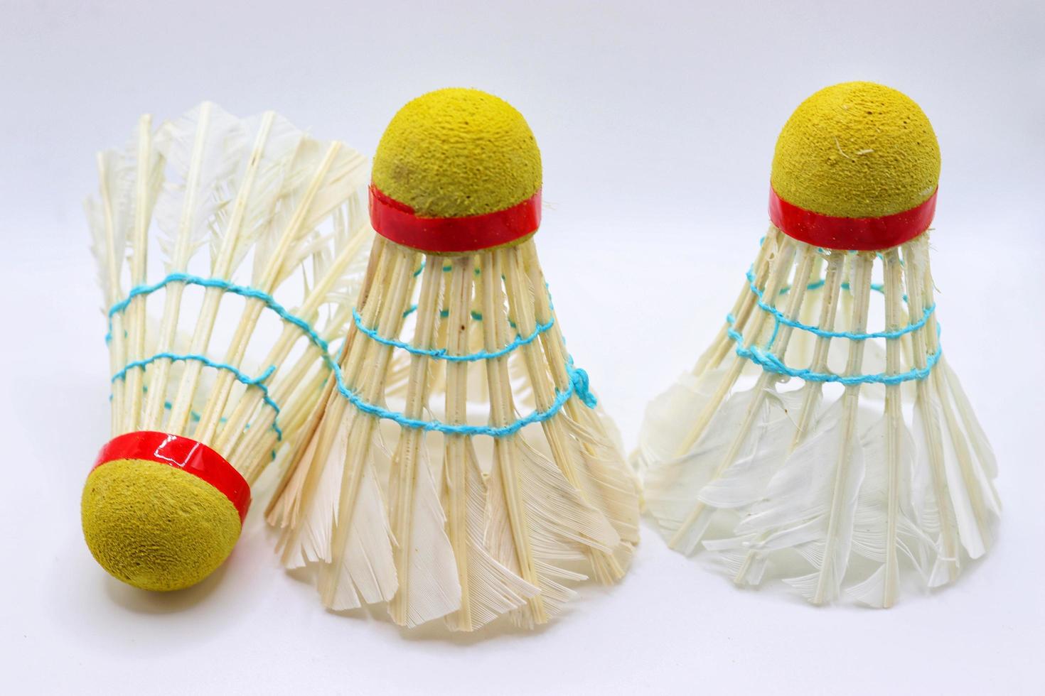 3 vit fjädrar badminton badmintonbollar på vit bakgrund foto
