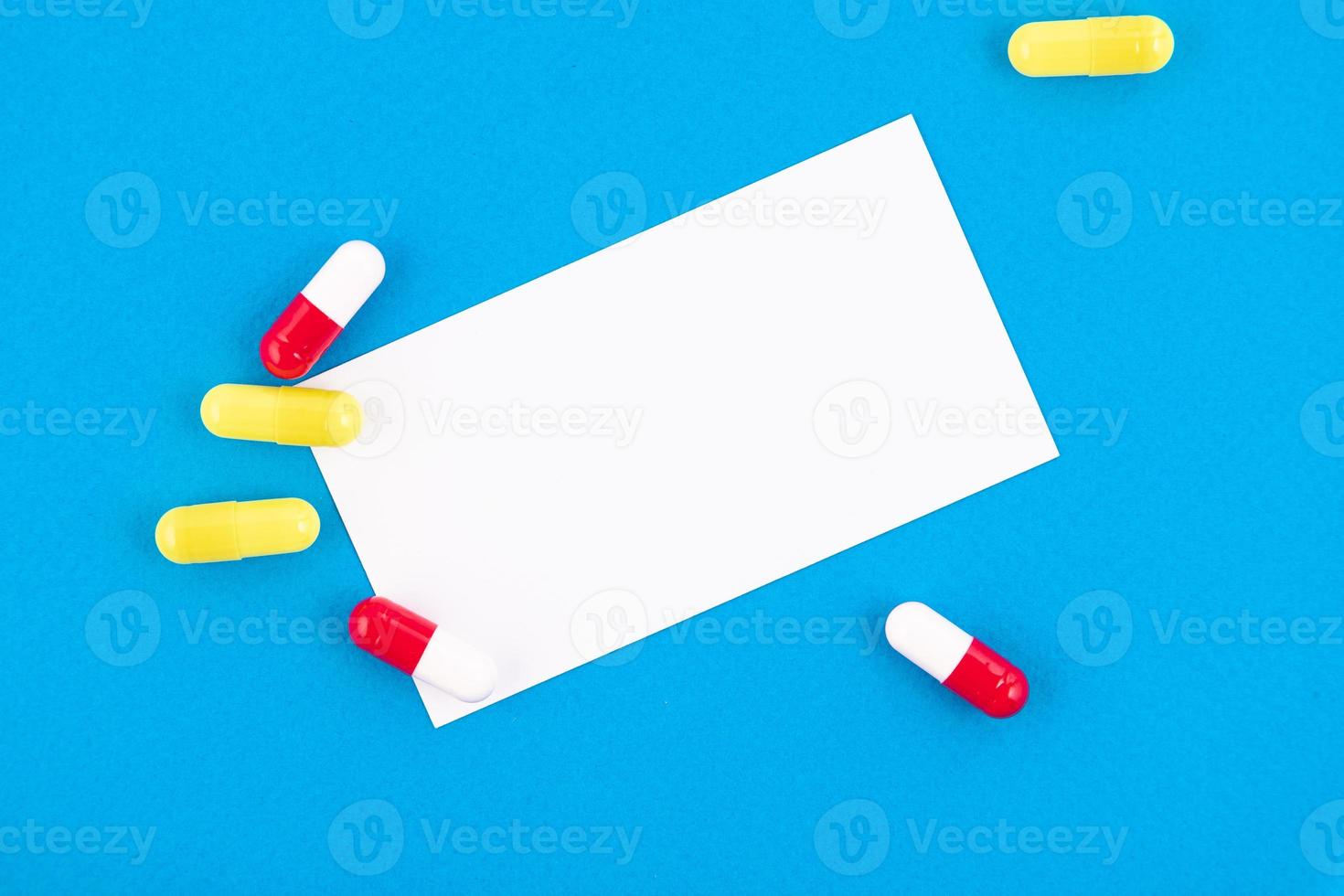 flerfärgad medicinsk kapslar, medicin med en vit tecken på en blå bakgrund. kopia Plats. foto