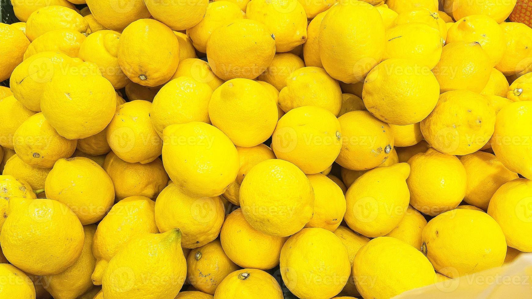 citron- bakgrund. de citron- frukt är staplade i en stor lugg. foto