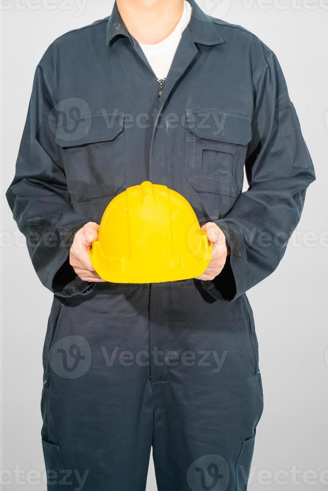 arbetare står i blå overall håller hjälm foto