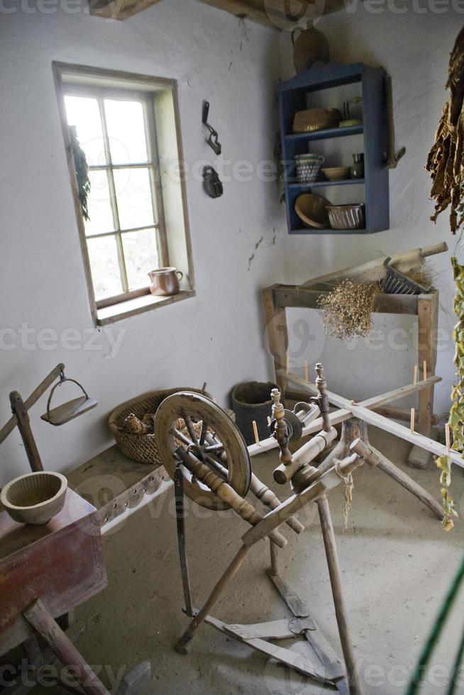 gammal trä- spinning hjul i de interiör av en lantlig historisk hydda i de museum foto